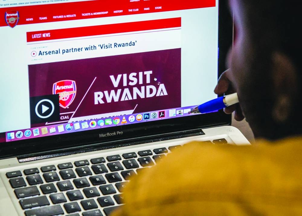 
File photo shows an Arsenal fan look at the website of England’s Arsenal Football Club that shows Rwanda’s new tourism promotion logo, in Kigali. 