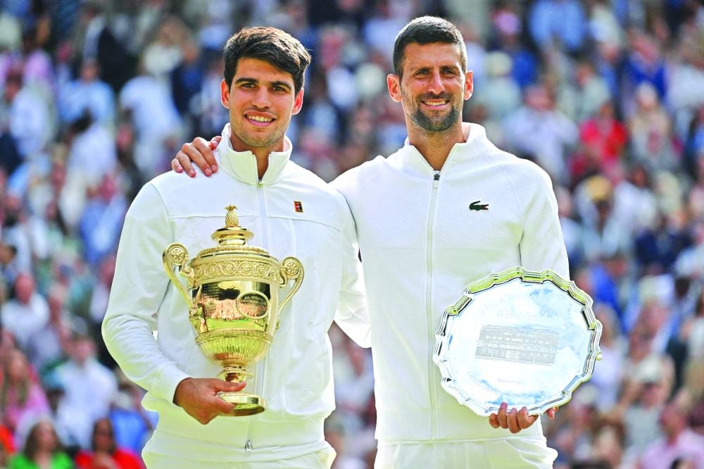 
Spain’s Carlos Alcaraz (left) and Serbia’s Novak Djokovic pose with their trophies at the end of the Wimbledon final on Sunday. (AFP) 