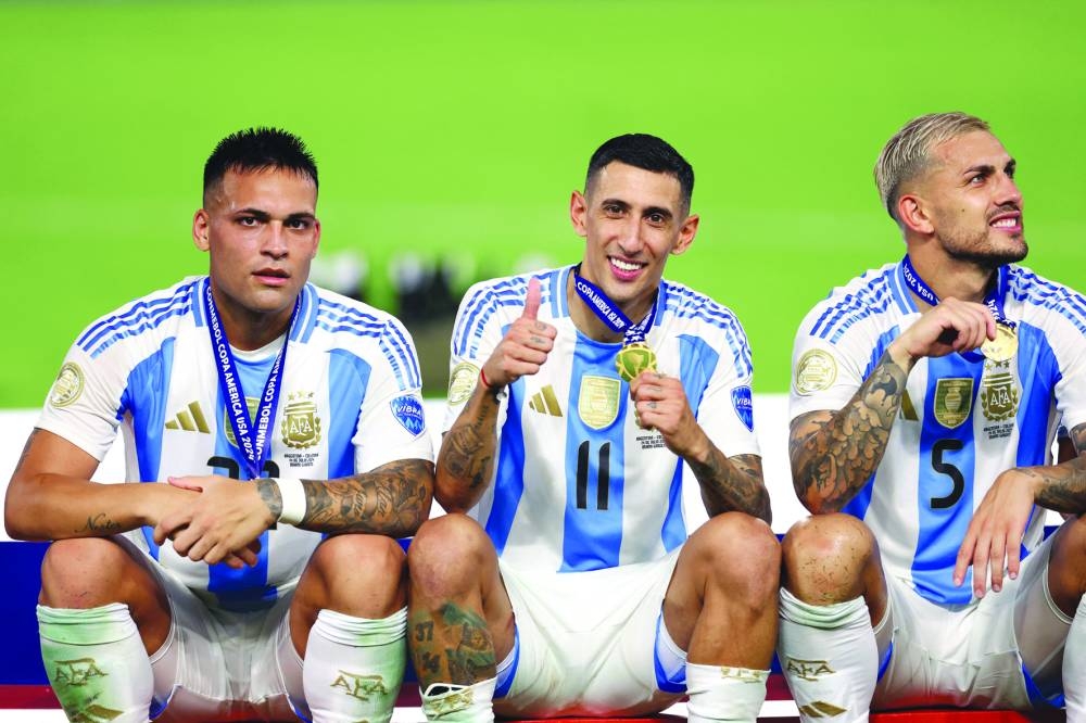 Angel Di Maria (centre) and Leandro Paredes of Argentina celebrate after their team’s victory Thomas Mueller. (AFP)