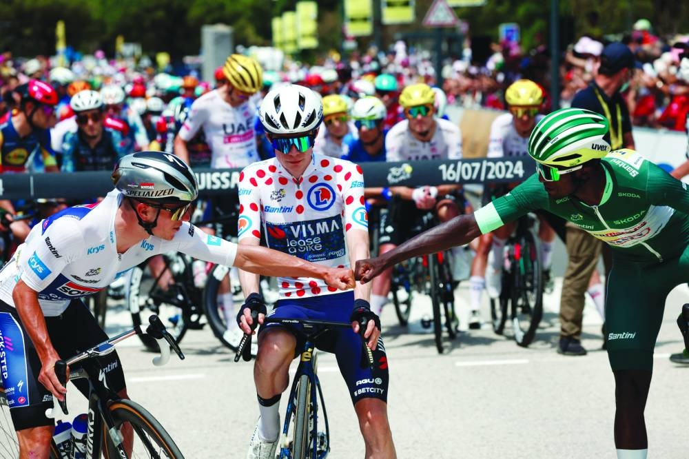 Jonas Vingegaard (centre), Remco Evenepoel (left) and Biniam Girmay wearing the green jersey are seen before the start of stage 16 of the Tour de France on Tuesday. (Reuters)