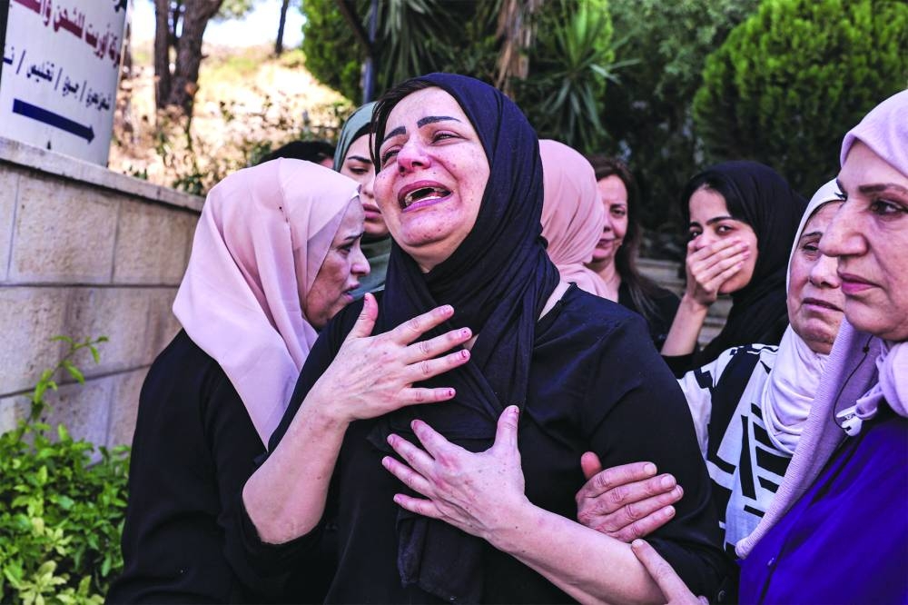 The mother (centre) of Ahmad Ramzi Sultan, a 20-year-old Palestinian of Gazan origin, is comforted as she mourns her son after he was killed during an Israeli army raid earlier in Al-Bireh north of Ramallah in the occupied West Bank during his funeral, on Tuesday.
