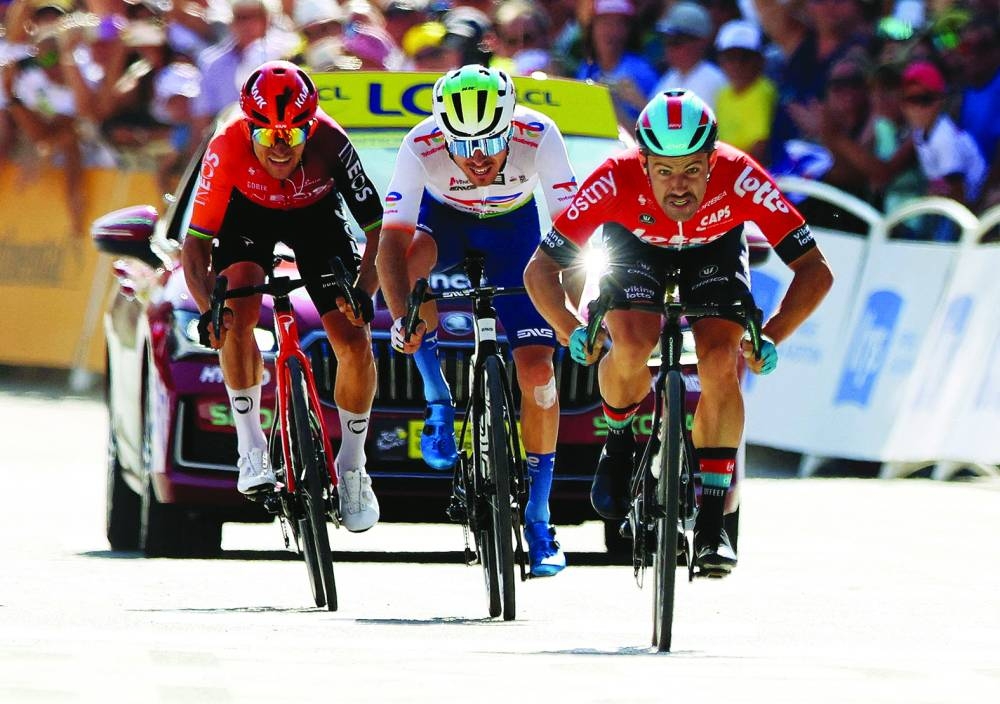 Lotto Dstny’s Victor Campenaerts in action before winning the stage followed by TotalEnergies’ Matteo Vercher and INEOS Grenadiers’ Michal Kwiatkowski during Stage 18 of the Tour De France on Thursday. (AFP)