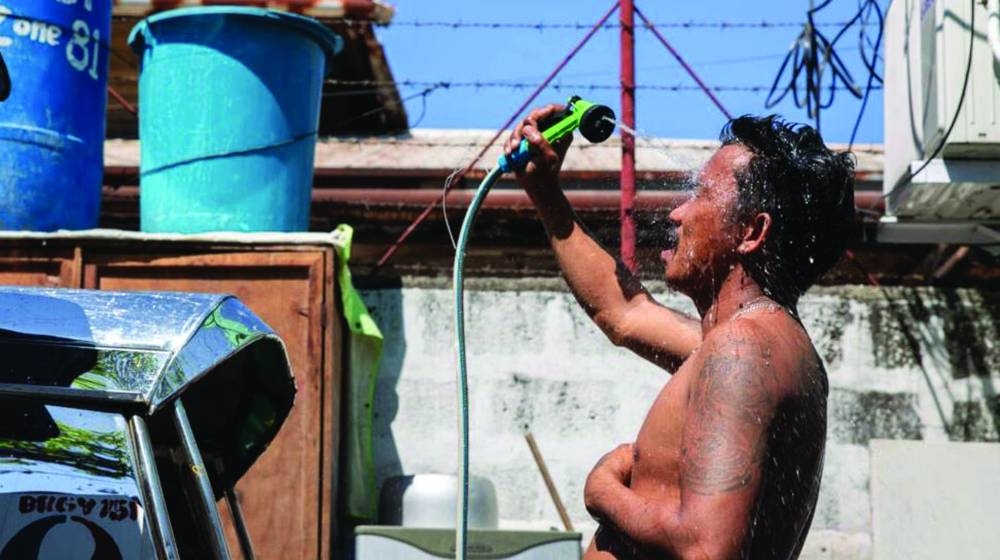 
A man takes a shower with a hose during a heat wave in Manila. (AFP) 