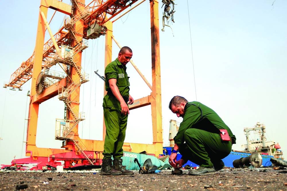 
Members of security forces inspect the debris littering a loading dock a day after Israeli strikes on the port of Yemen’s Houthi-held city of Hodeidah, yesterday. 