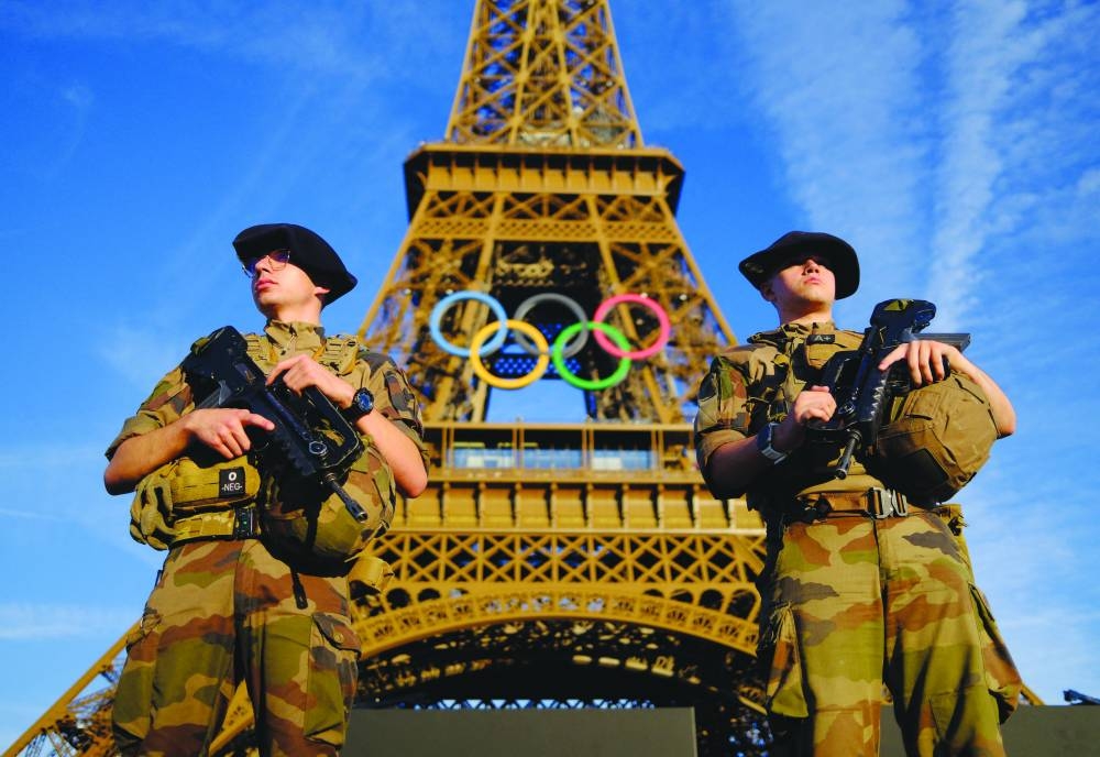 
Soldiers patrol on a street in front of the Eiffel Tower in Paris ahead of the Olympics, which begins from Friday. (Reuters) 