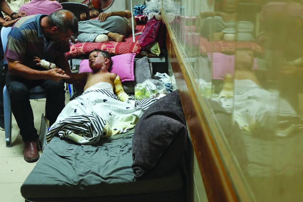 Palestinian boy Mahmoud al-Saafin, who suffers from burns caused by an Israeli strike, according to medics, is tended to by his father at Al-Aqsa Martyrs Hospital in Deir Al-Balah in the central Gaza Strip.