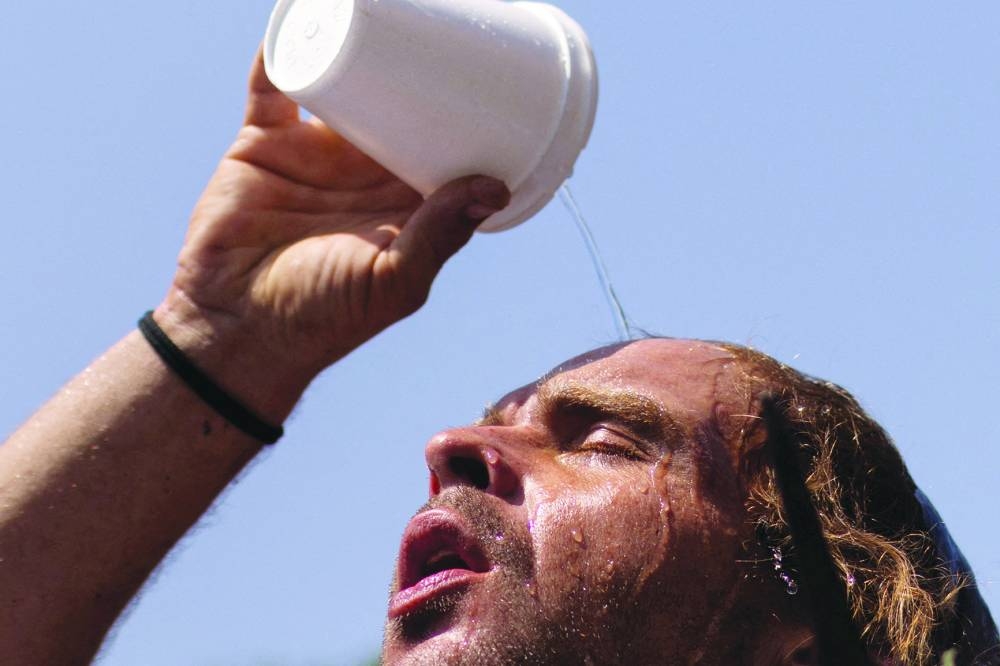 A man pours water atop his head outside the Emergency Aid Coalition during a heat wave in Houston, Texas. (Reuters) 