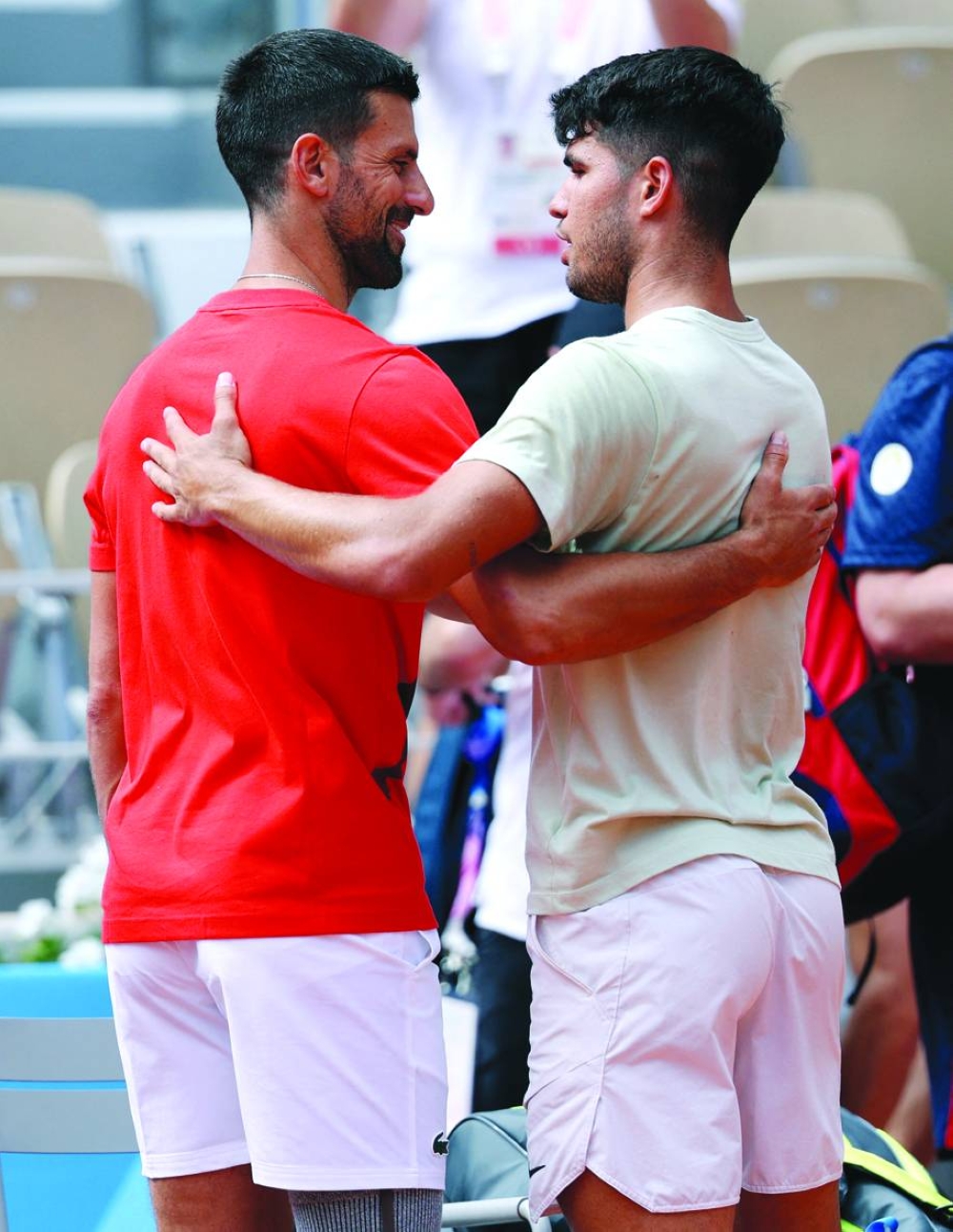 Novak Djokovic (left) of Serbia and Carlos Alcaraz of Spain embrace during a training session at the Roland-Garros Stadium in Paris on Thursday. (Reuters)
