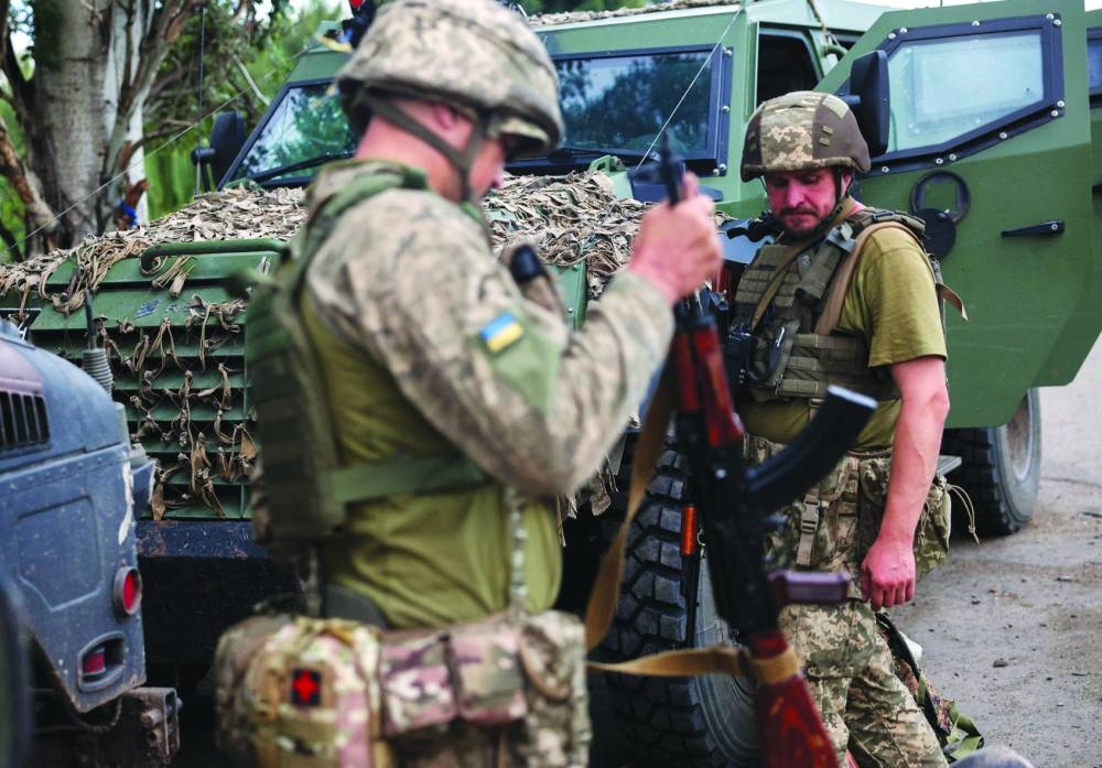 Ukrainian servicemen adjust combat equipment before being sent to the front line at an unspecified location in the Donetsk region, on July 22, amid the Russian invasion in Ukraine. 