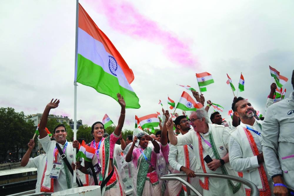 Indian athletes wave their national flags from a boat on the Seine River during the opening ceremony of the Paris 2024 Olympics. (Reuters)