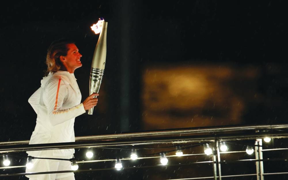 Amelie Mauresmo holds the Olympic torch ahead of lighting the Olympic cauldron during the opening ceremony. (Reuters)