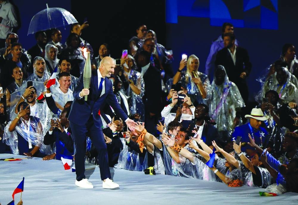 Zinedine Zidane holds the Olympic torch ahead of lighting the Olympic cauldron during the opening ceremony. (Reuters)