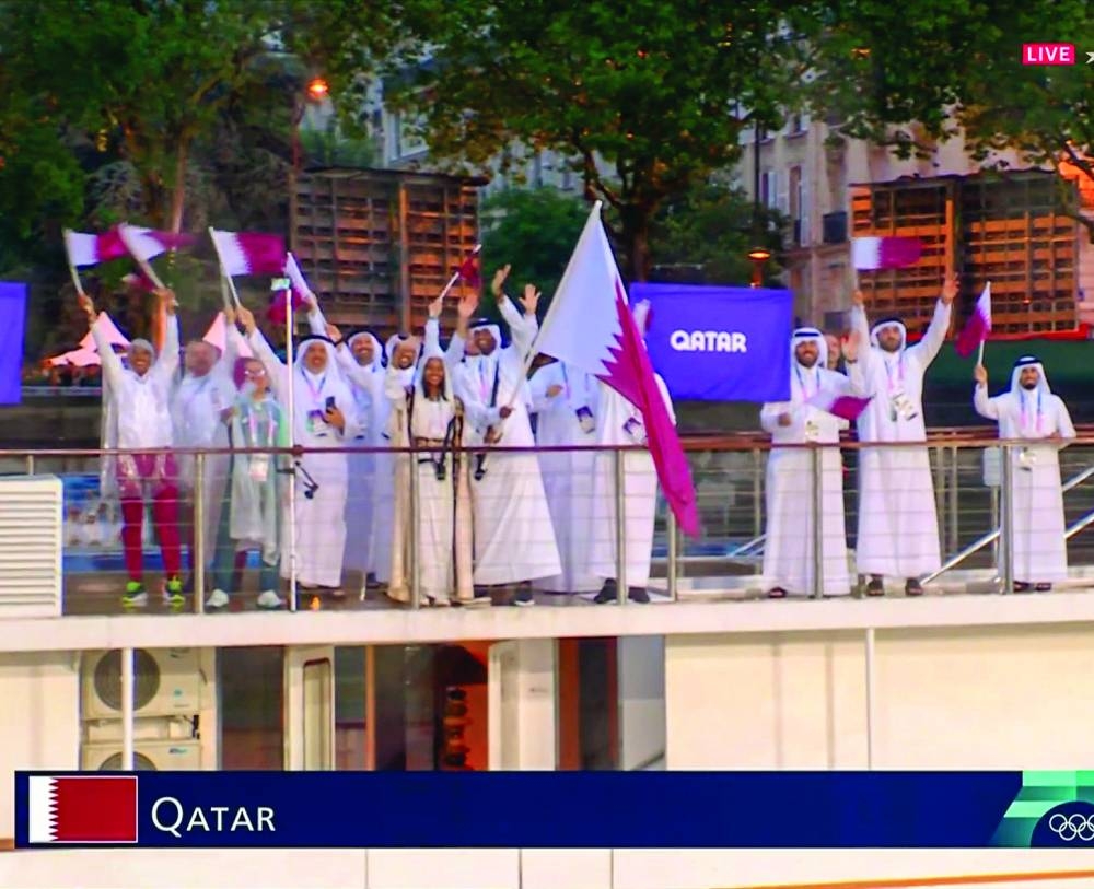 Athletes of Qatar are seen aboard a boat in the floating parade on the river Seine during the opening ceremony.