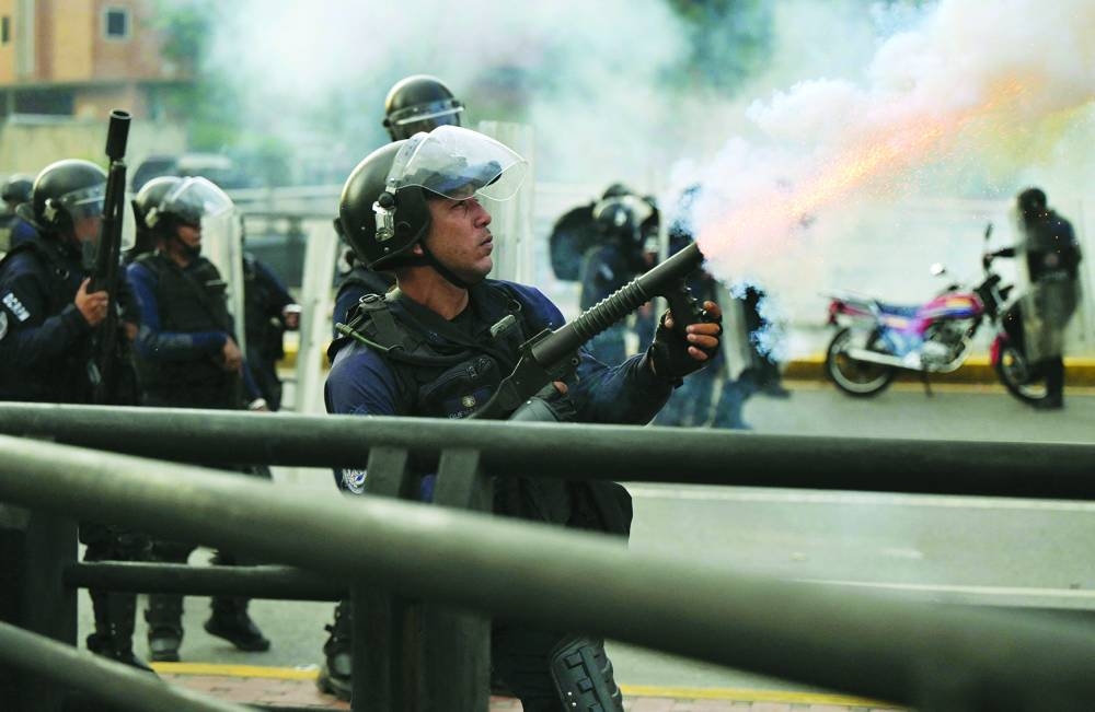 
A police officer fires tear gas during a protest against Maduro’s government in Caracas. – AFP 