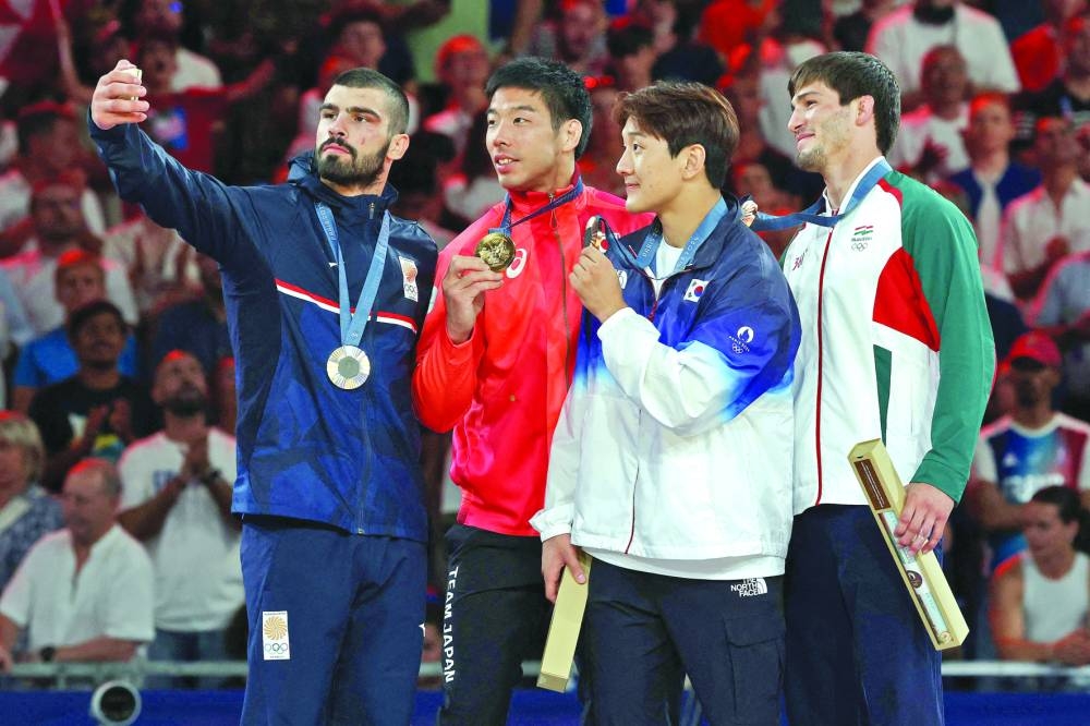 FROM LEFT: Silver medallist Georgia’s Tato Grigalashvili, gold medallist Japan’s Takanori Nagase and bronze medallists South Korea’s Lee Hye-kyeong, Tajikistan’s Somon Makhmadbekov pose for a selfie on the podium after the judo men’s -81kg of the Paris 2024 Olympic Games at the Champ-de-Mars Arena, in Paris yesterday. (AFP) 