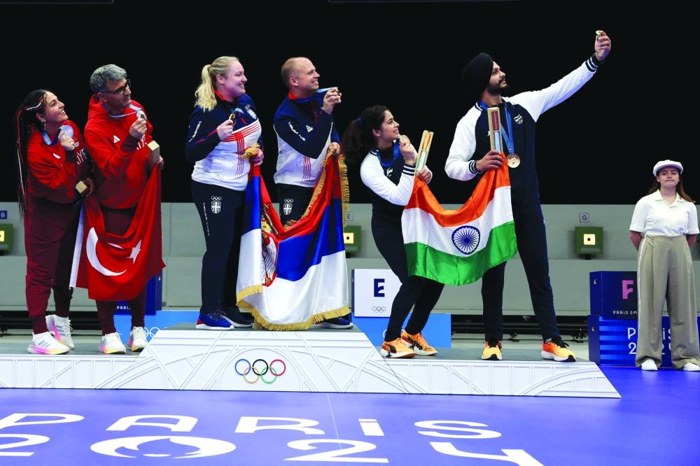 From left: 10m air pistol mixed team event silver medallists Sevval Ilayda Tarhan and Yusuf Dikec of Turkiye, gold medallists Zorana Arunovic and Mikec Damir of Serbia and bronze medallists Manu Bhaker and Sarabjot Singh of India take a selfie on the podium at the Paris Olympic Games at Chateauroux Shooting Centre yesterday. (AFP) 
