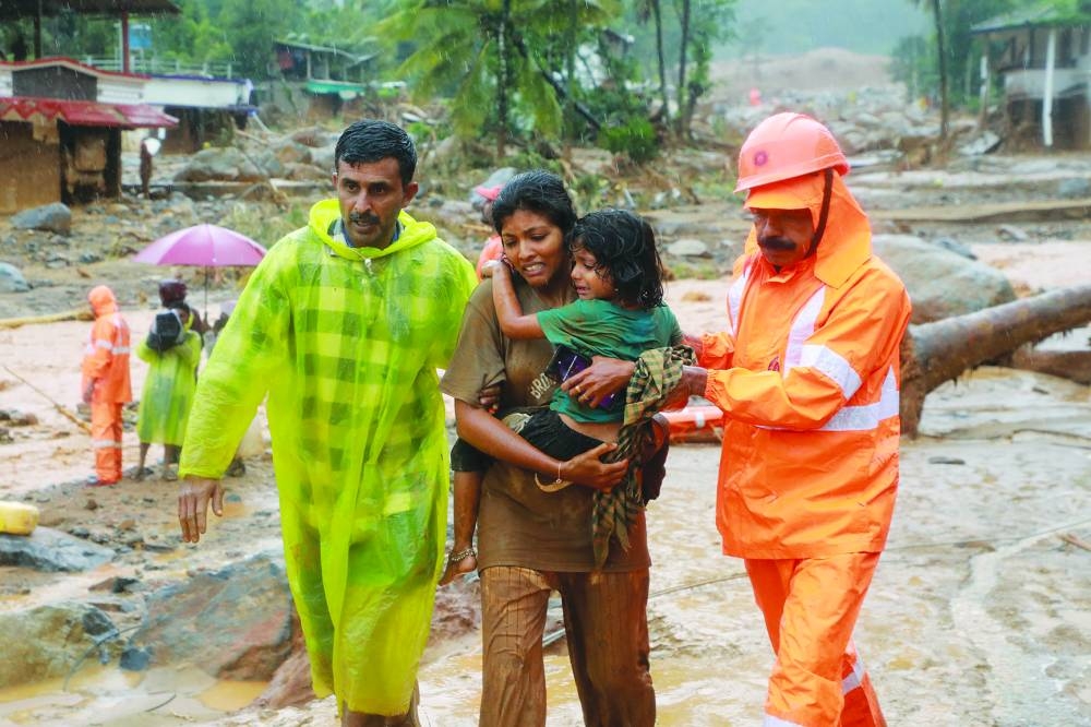 
Rescuers help residents to move to a safer place, at a landslide site after multiple landslides in the hills, in Wayanad, Kerala, India, yesterday. (Reuters) 
