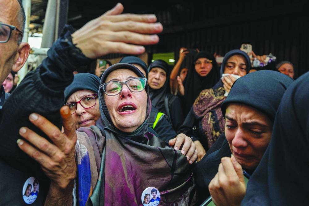 Woman mourn during the funeral of the two children, a day after they were killed in an Israeli strike on a building in Beirut's southern suburbs.