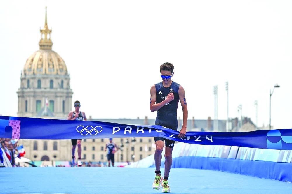 Britain’s Alex Yee celebrates after winning the men’s individual triathlon race on Wednesday. (AFP) 