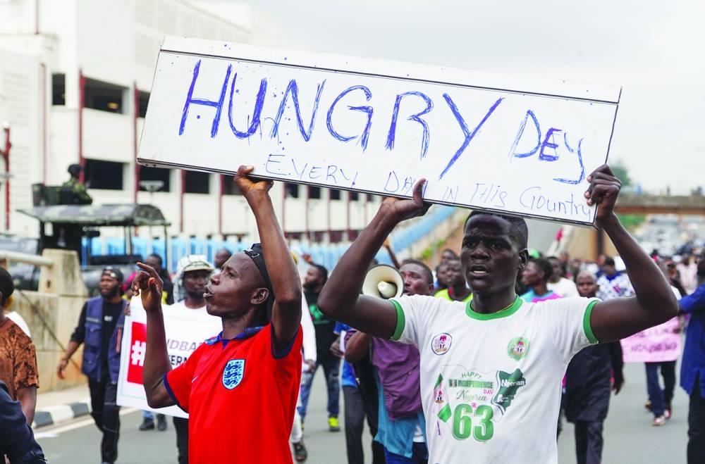 Demonstrators react as Nigerian policemen fire tear gas canisters during the End Bad Governance protest in Abuja on Thursday. (Reuters)