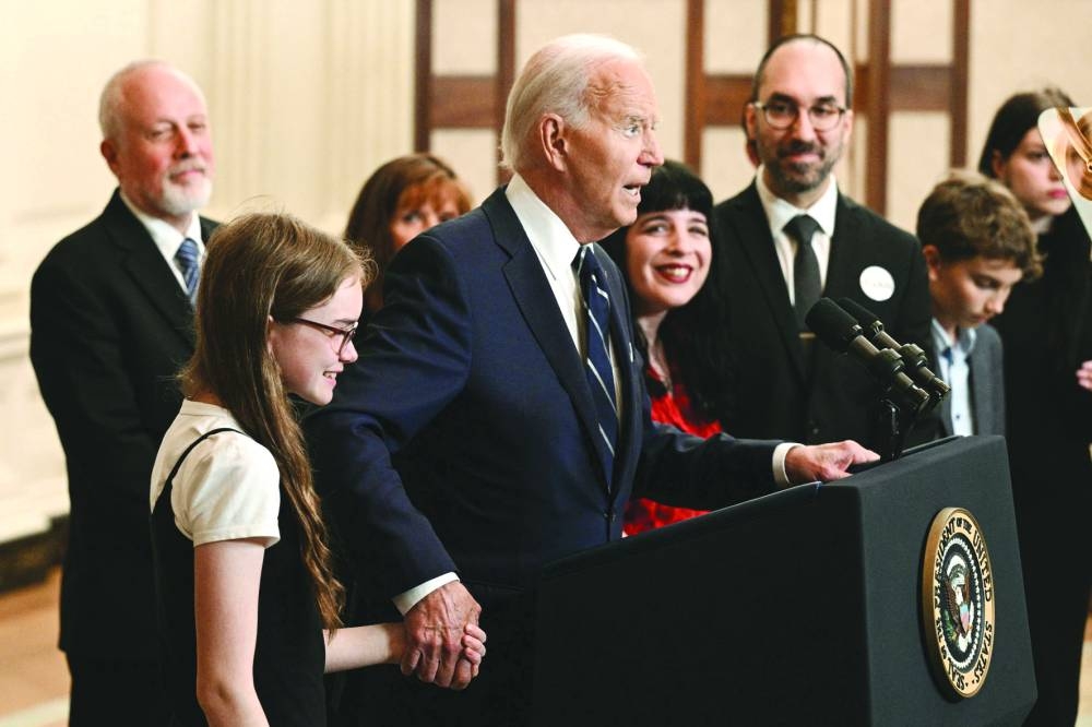 
Biden holds the hand of the 12-year-old daughter of Aslu Kurmasheva as he speaks about the prisoner exchange with Russia, in the State Dining Room of the White House in Washington, DC. – AFP 