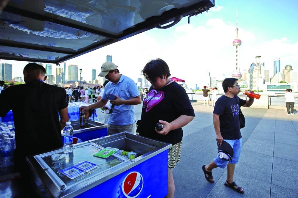 
People buy cold drinks from a vendor on The Bund amid a red alert for heatwave, in Shanghai. 