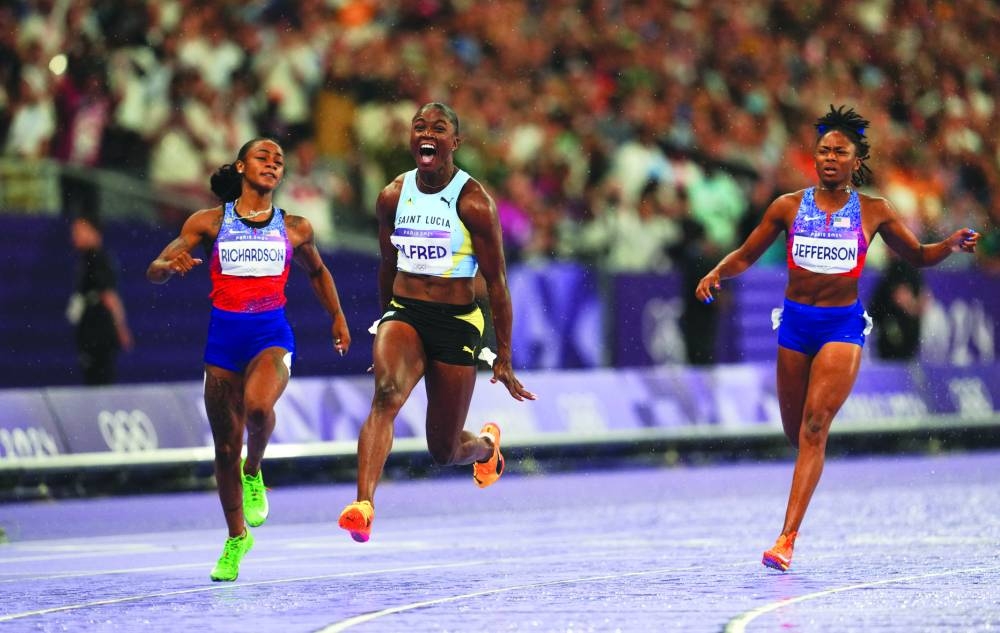 Julien Alfred of Saint Lucia celebrates after crossing the line to win the 100m gold ahead of silver medallist Sha’Carri Richardson of US and bronze medallist Melissa Jefferson of US during the Paris Olympics at Stade de France on Saturday . (Reuters) 