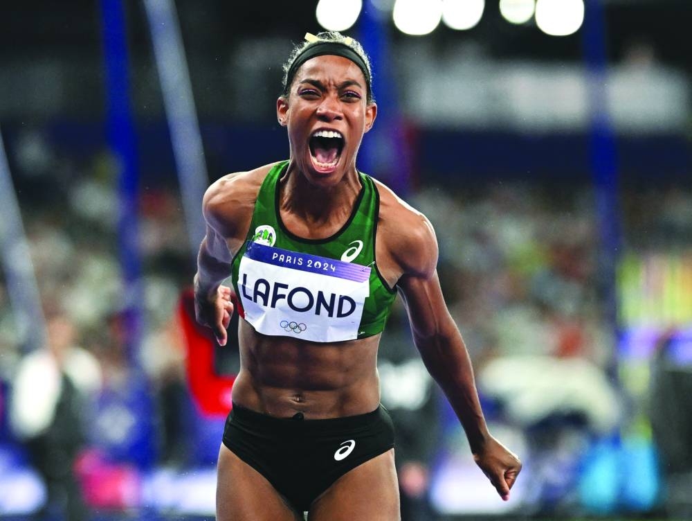 Thea LaFond of Dominica celebrates after winning the triple jump gold. 