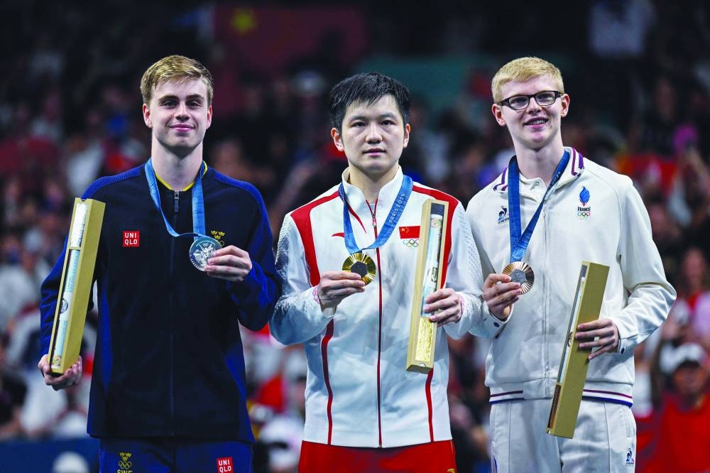 
Silver medallist Sweden’s Truls Moregard (left), gold winner China’s Fan Zhendong (centre) and bronze medallist France’s Felix Lebrun pose on the podium yesterday. (AFP) 