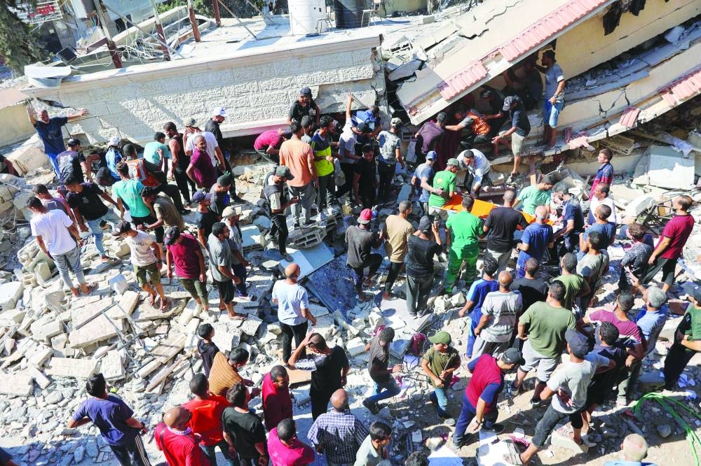 People and emergency crews look for survivors following Israeli bombardment on the Al-Nassr school that houses displaced Palestinians, West of Gaza city, yesterday.