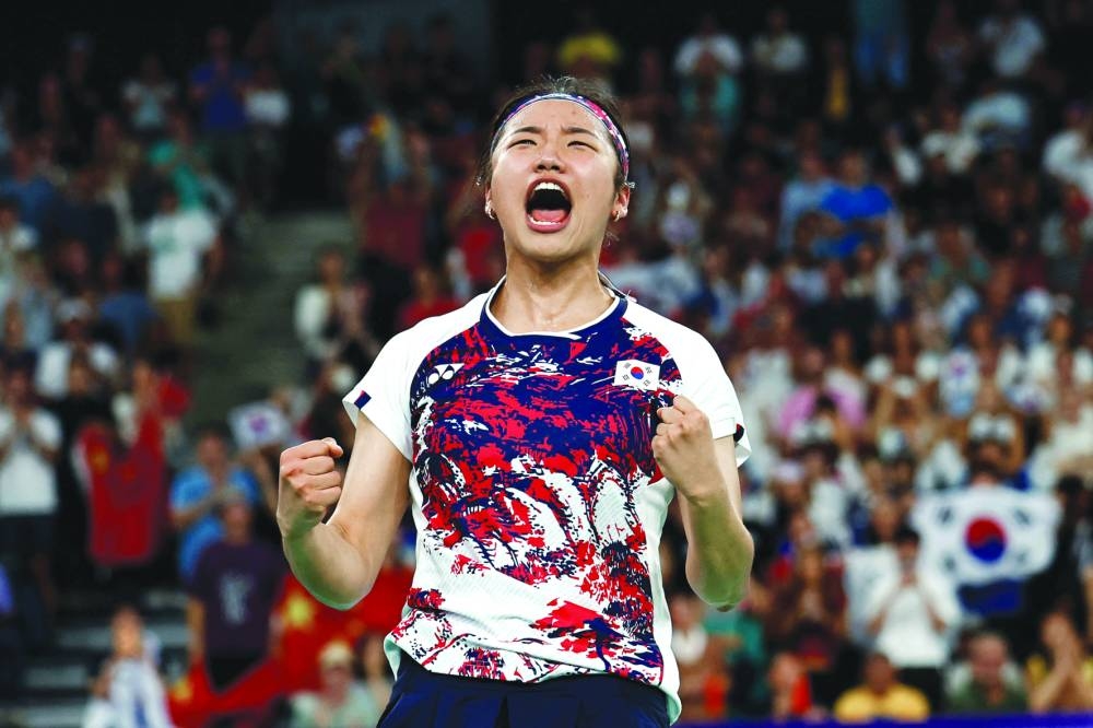 South Korea’s An Se-young reacts after winning the women’s singles badminton final during the Paris 2024 Olympic Games at Porte de la Chapelle Arena in Paris on Monday. Right: Denmark’s gold medallist Viktor Axelsen celebrates after winning the men’s badminton gold medal on Monday. (AFP)