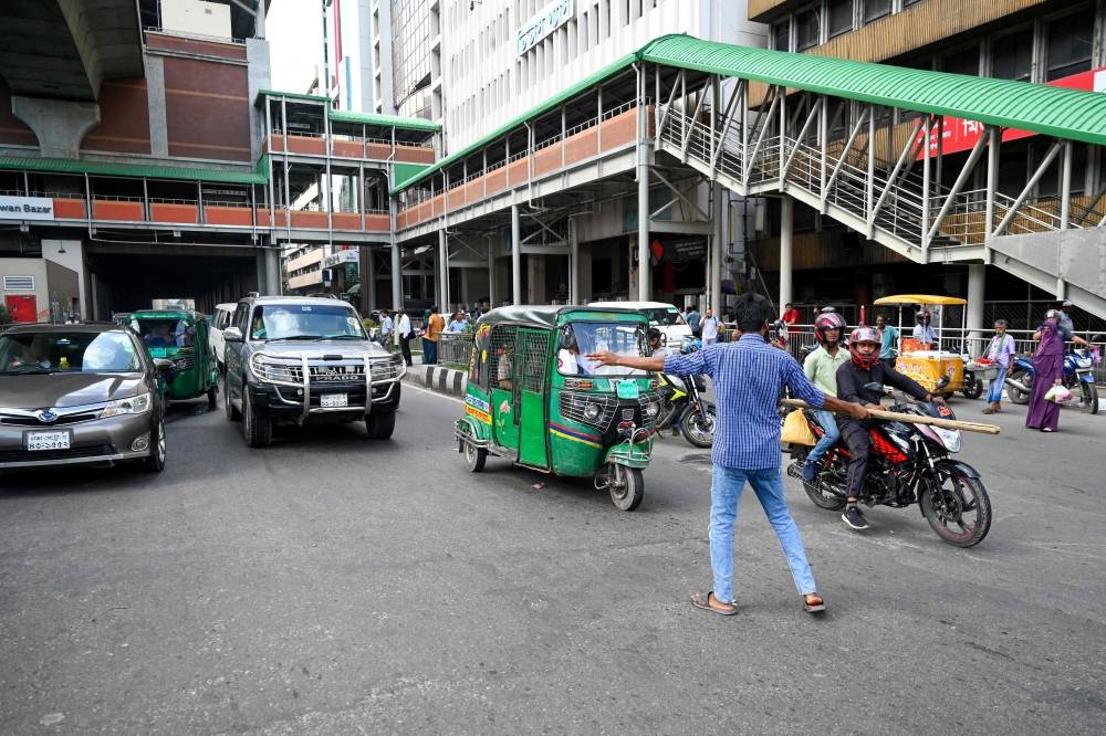 A Bangladeshi student controls the traffic as police went on strike in Dhaka on Tuesday. AFP