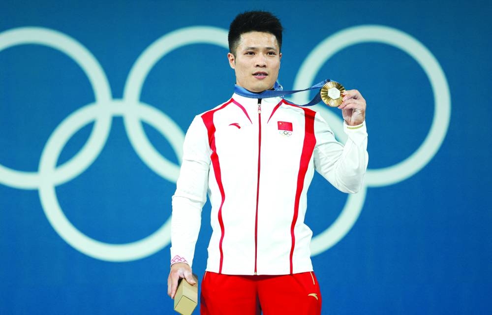 Fabin Li of China poses after winning the weightlifting men’s 61kg gold at the Paris Olympics. 