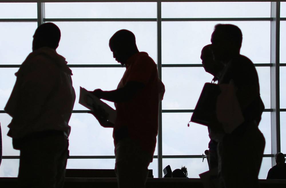 People looking for work stand in line to apply for a job during a job fair in Miami, Florida. The July employment report showed US hiring slowed markedly while the unemployment rate rose to 4.3%, causing its three-month moving average to exceed the 12-month low by half a percentage point, and triggering the so-called Sahm Rule.