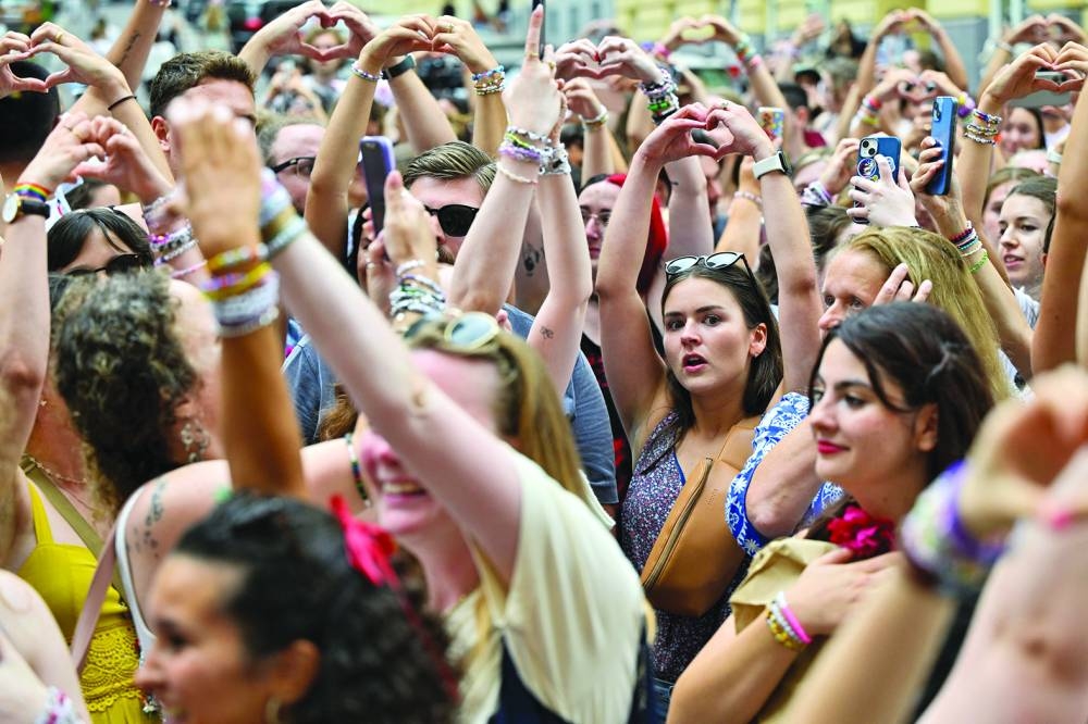 Fans of the singer Taylor Swift make a heart shape with their hands as they gather following the cancellation of three Taylor Swift concerts at Happel stadium in Vienna. – Reuters