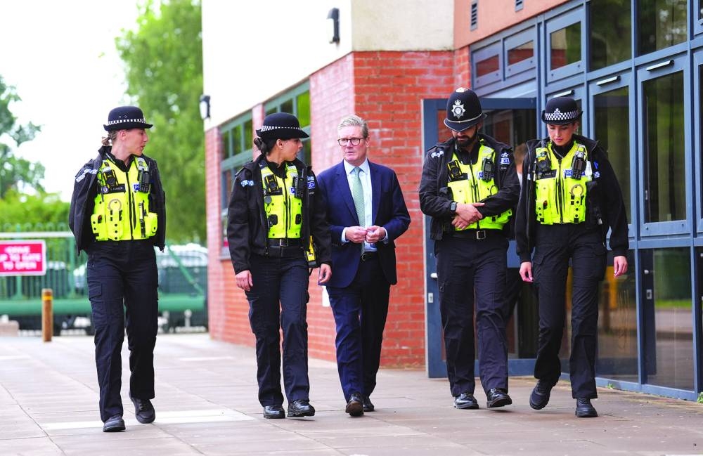 
British Prime Minister Keir Starmer speaks with members of the West Midlands Police Force during a visit to the Arden Academy in Solihull, West Midlands, Britain, yesterday. 