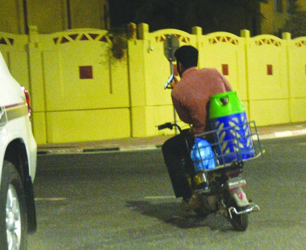 A delivery man on an e-bike seen using mobile phone while riding without any safety measures on a Doha street. PICTURES: Shaji Kayamkulam.