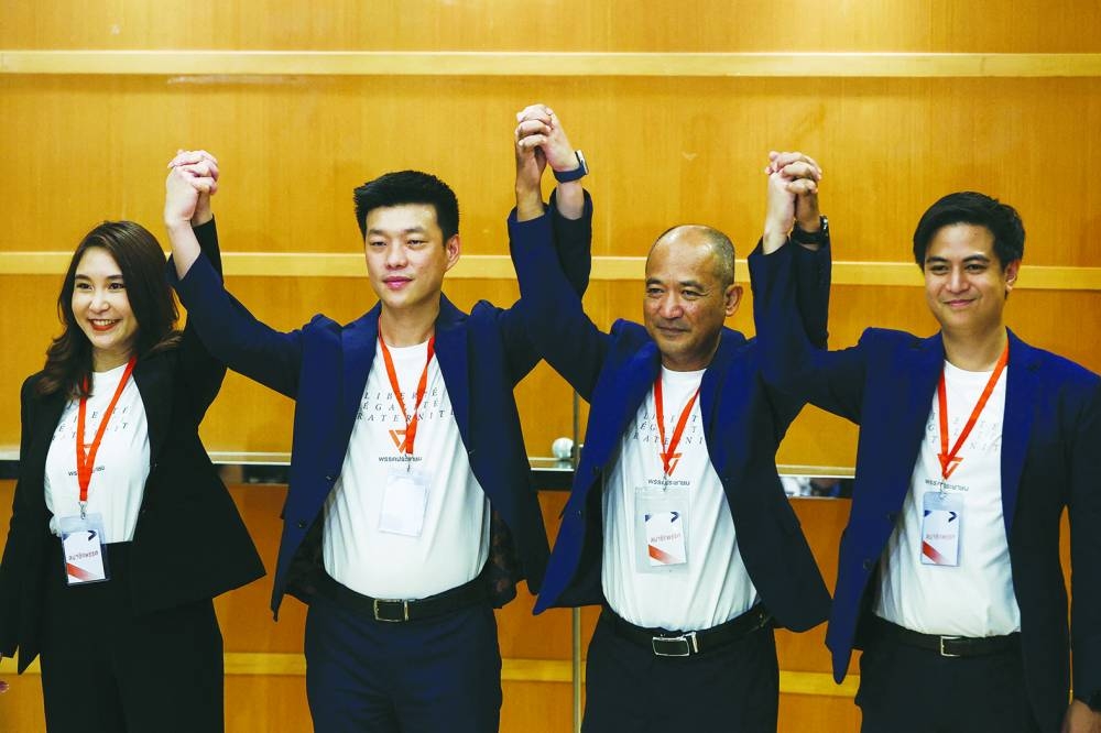 People's Party leader, Natthaphong Ruengpanyawut and party members pose for a picture.