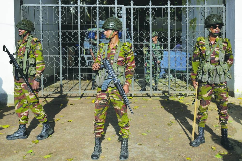 Security personnel stand guard next to a police station in Dhaka.