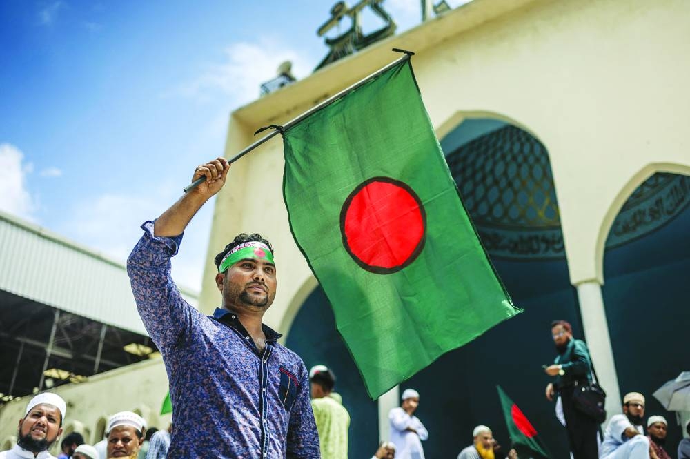 A man carries Bangladesh's national flag at the Bangladesh National Mosque, Baitul Mukkaram in Dhaka.