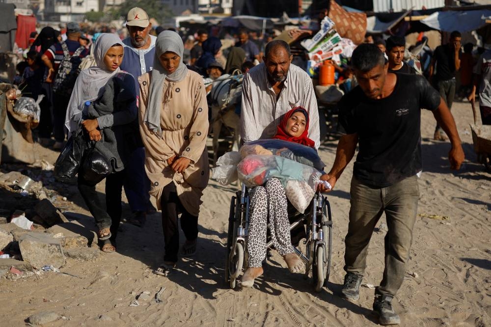 Displaced Palestinians make their way as they flee the eastern part of Khan Younis following an Israeli army evacuation order.