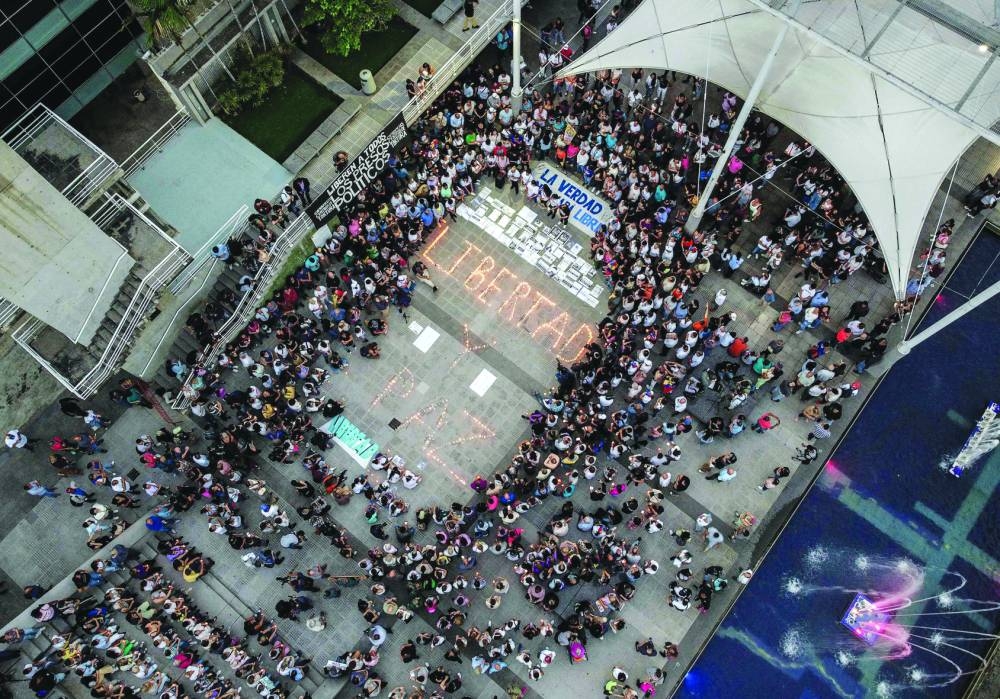 Aerial view shows people surrounding lit candles forming the words 'Freedom and Peace' during a vigil in Caracas on Thursday called by the opposition demanding freedom for political prisoners arrested during protest following the contested re-election of Venezuelan President Nicolas Maduro. – AFP