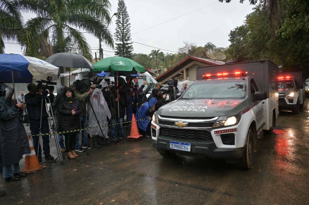 Police forensic trucks leave the Recanto Florido Condominium, where an airplane crashed with 61 people on board in Vinhedo, Sao Paulo State, Brazil. AFP