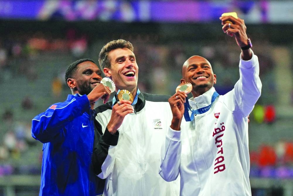 Bronze medallist Mutaz Barshim takes selfie as he poses with gold medallist Hamish Kerr (centre) of New Zealand and silver medallist Shelby McEwen of US. (Reuters) 