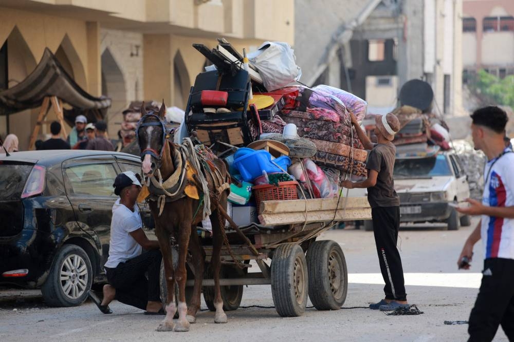 Palestinians use a horse-pulled cart to transport their belongings as they flee the Hamad residential district and its surroundings in Khan Yunis in the southern Gaza Strip after receiving a warning from the Israeli army to evacuate the area on Sunday. AFP
