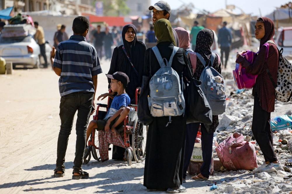 A disabled Palestinian child sits in a wheelchair as people flee the Hamad residential district and its surroundings in Khan Yunis in the southern Gaza Strip after receiving a warning from the Israeli army to evacuate the area on August 11, 2024, amid the ongoing conflict between Israel and the Hamas militant group. (Photo by Bashar TALEB / AFP)