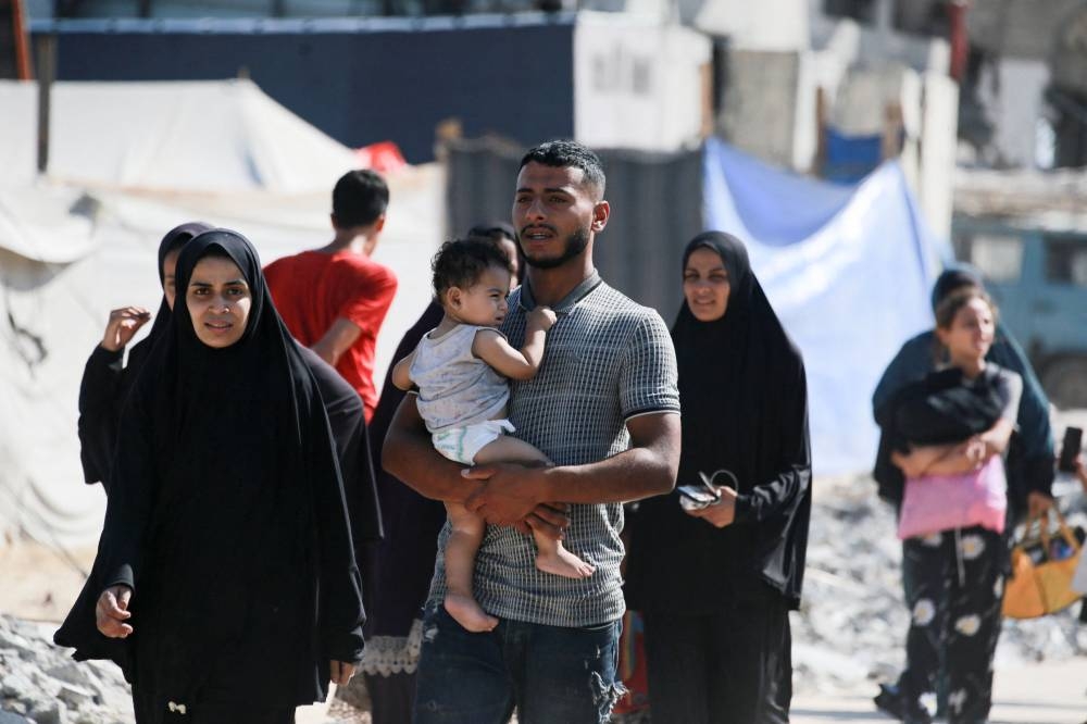 Palestinians flee the Hamad residential district and its surroundings in Khan Yunis in the southern Gaza Strip after receiving a warning from the Israeli army to evacuate the area on Sunday. AFP