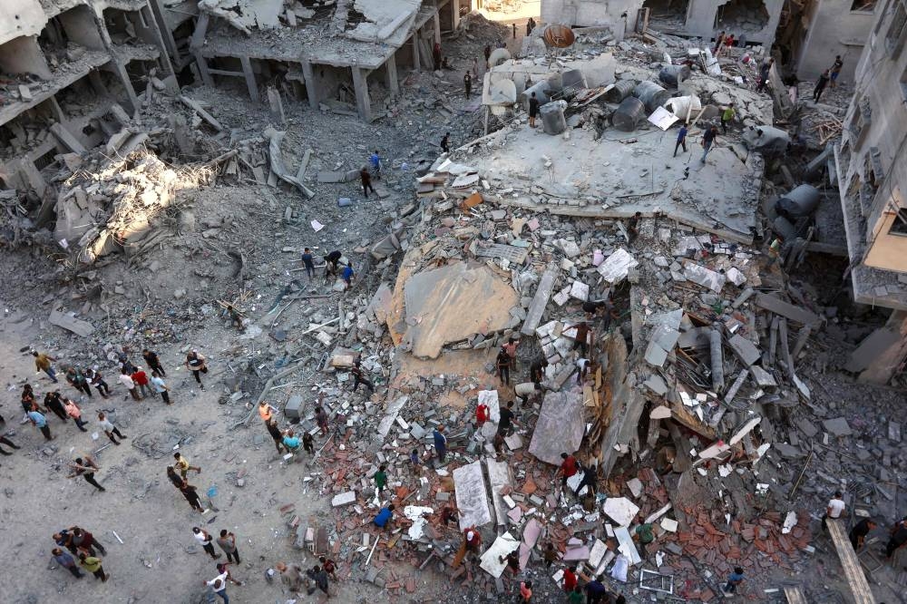 People inspect the damage in Gaza City's Sheikh Radwan neighbourhood in Gaza City following Israeli bombardment Sunday.