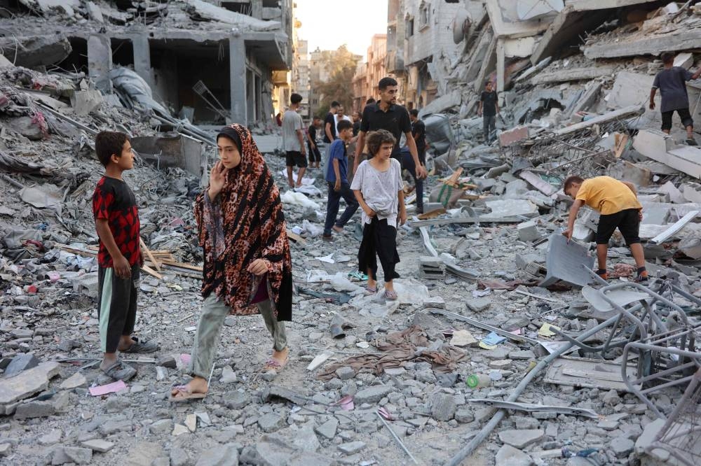 People inspect the damage in Gaza City's Sheikh Radwan neighbourhood following Israeli bombardment Sunday.