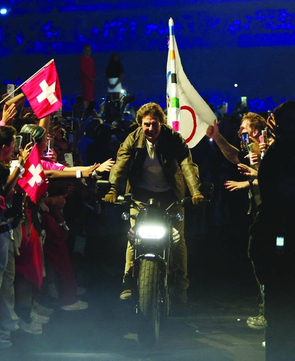 
American actor Tom Cruise rides a motorbike with the Olympics flag during the closing ceremony of Paris Olympics Games at the Stade de France yesterday. (Reuters) 